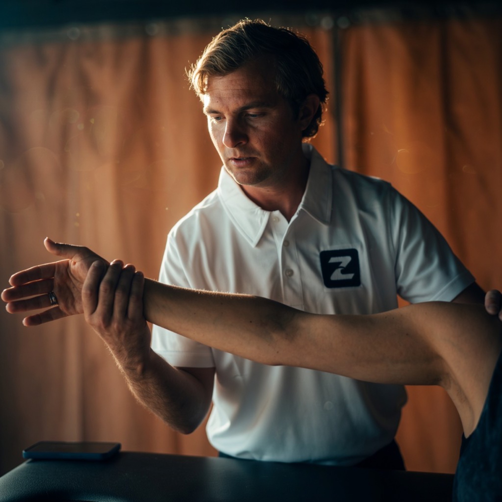Dr. Zombek assessing a patient’s arm during a treatment session
